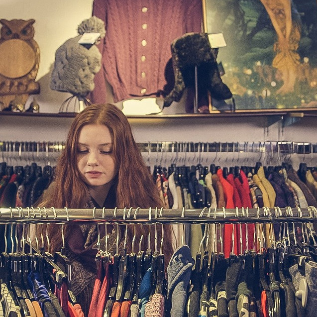 Person browsing a charity shop clothes rail